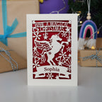 A personalised laser cut girls' Christmas card with a unicorn and the words "Have a magical Christmas, Name"