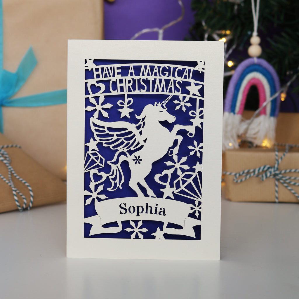 A personalised laser cut girls' Christmas card with a unicorn and the words "Have a magical Christmas, Name"