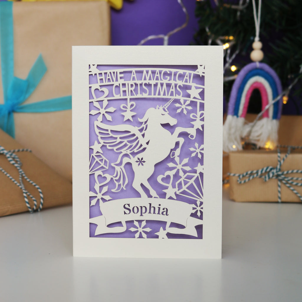 A personalised laser cut girls' Christmas card with a unicorn and the words "Have a magical Christmas, Name"