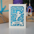 A personalised laser cut girls' Christmas card with a unicorn and the words "Have a magical Christmas, Name"