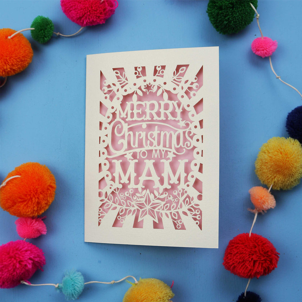 Laser cut Mam Christmas card with 'Merry Christmas to my Mam' text on a blue background with colourful pom-poms.
