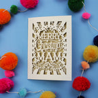 Laser cut Mam Christmas card with 'Merry Christmas to my Mam' text on a blue background with colourful pom-poms.