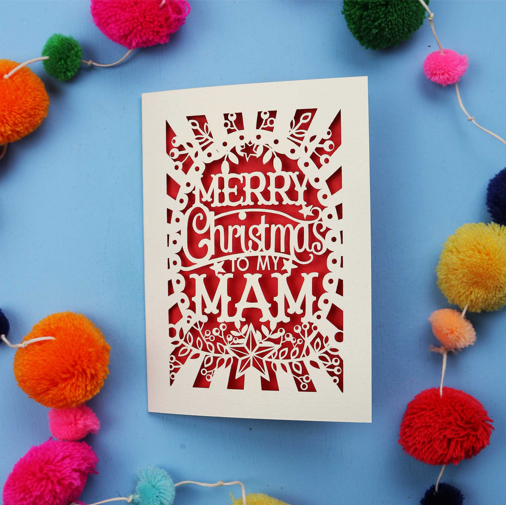 Laser cut Mam Christmas card with 'Merry Christmas to my Mam' text on a blue background with colourful pom-poms.