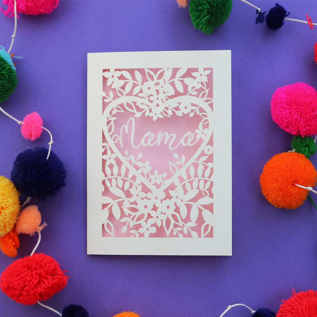 A cut out mother's day card with "mama" inside a heart surrounded by flowers