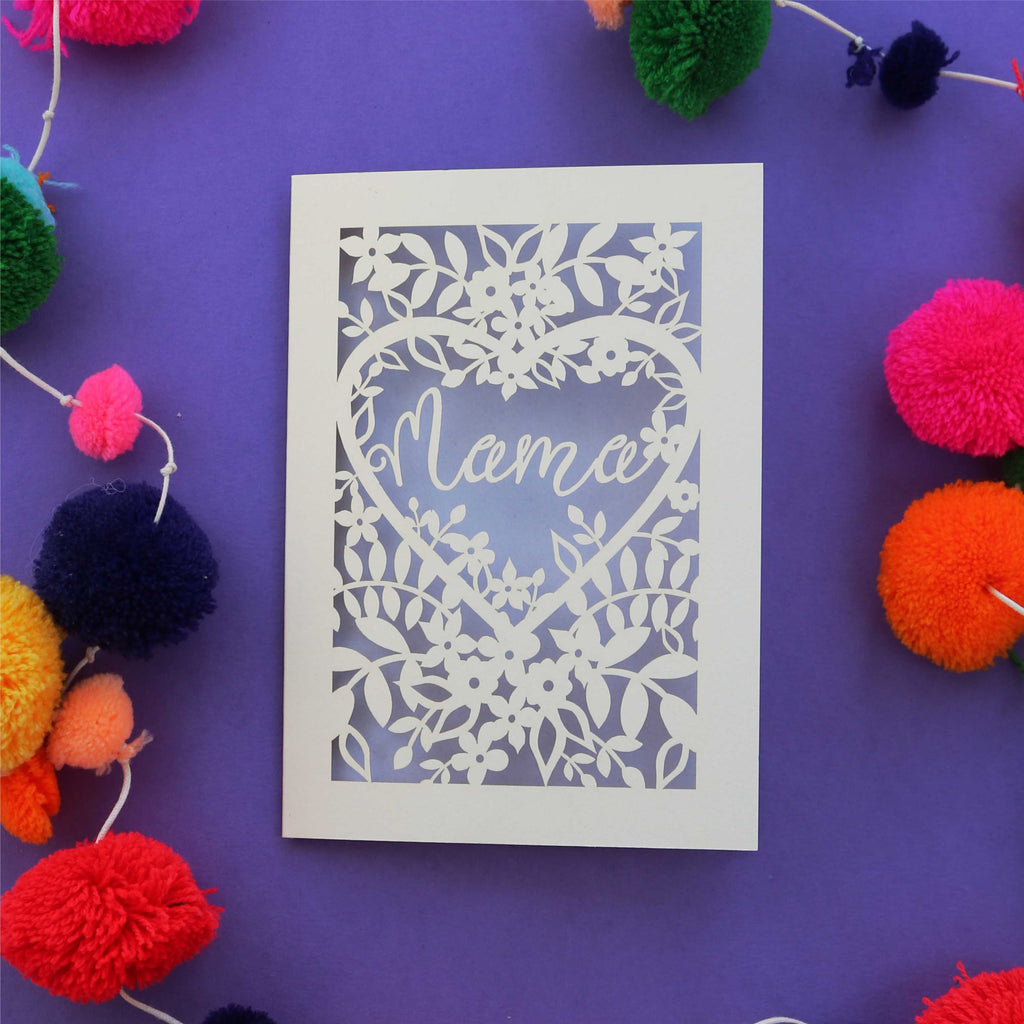 A greetings card that says "Mama" in a heart with flowers around the border