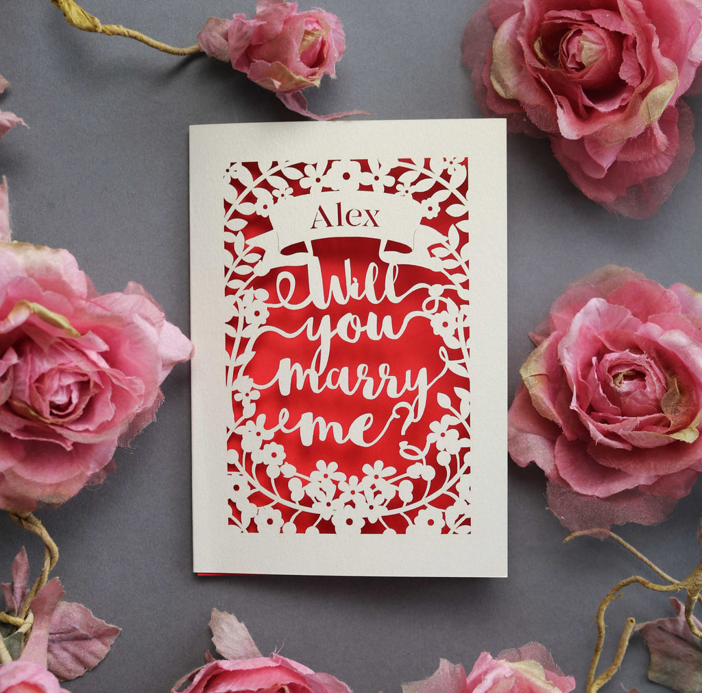 A laser cut card that says "Name, will you marry me?"
