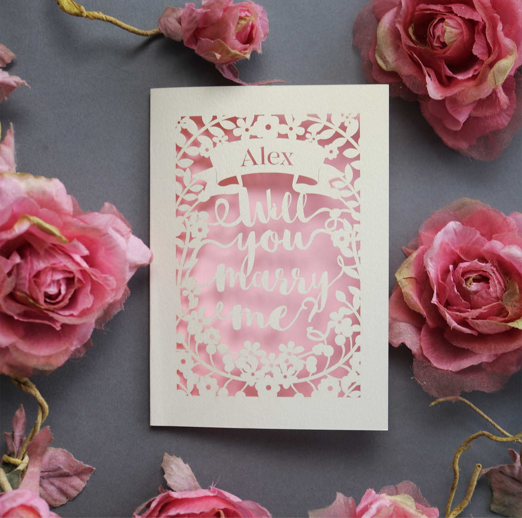 A personalised proposal card, laser cut from cream card with a candy pink paper behind