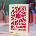 Personalized Bat Mitzvah card with decorative cut-out  star design and text 'Mazel Tov Olivia on your Bat Mitzvah' on a desk with stationery items.
