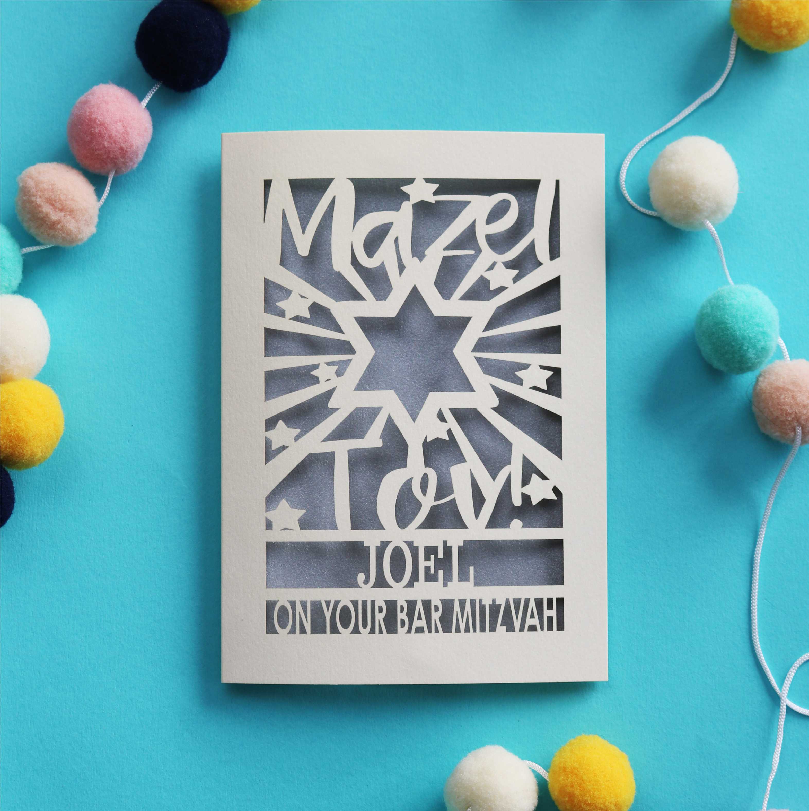 A personalised laser cut card for a Bar Mitzvah that says "Mazel Tov! Name, on your Bar Mitzvah"