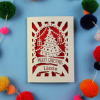 Laser cut Christmas card with decorative elements on a blue background