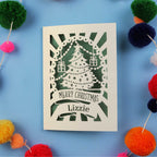 Laser cut Christmas card with decorative elements on a blue background