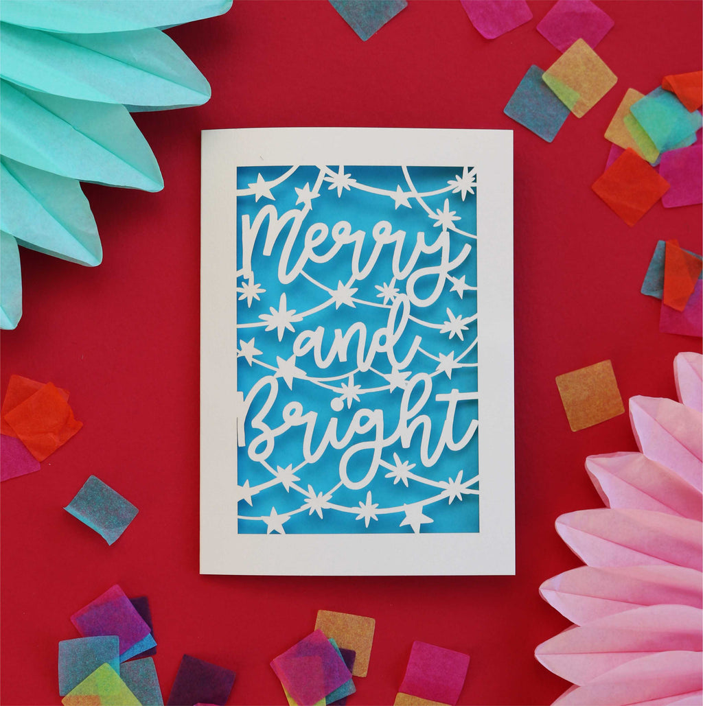 a paper cut Christmas card with a blue paper insert