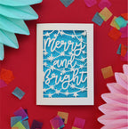 a paper cut Christmas card with a blue paper insert