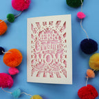Laser cut Mom Card with 'Merry Christmas to my Mom' text surrounded by colourful pom-poms on a blue background
