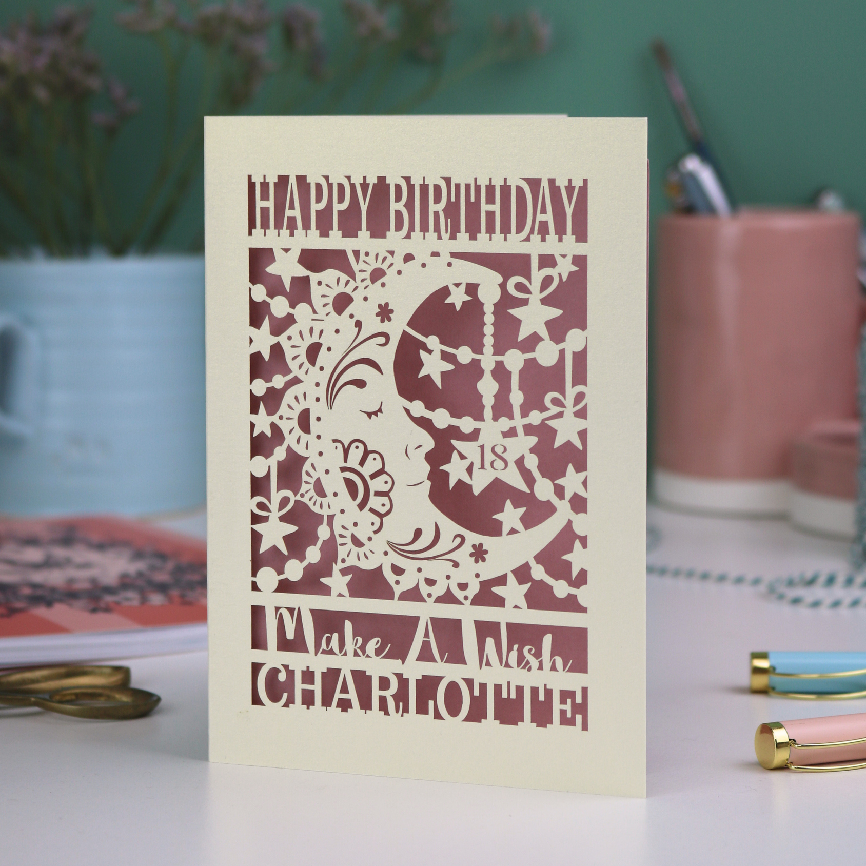 Laser cut moon 18th Birthday card with blue star and moon design on a desk with stationery items.