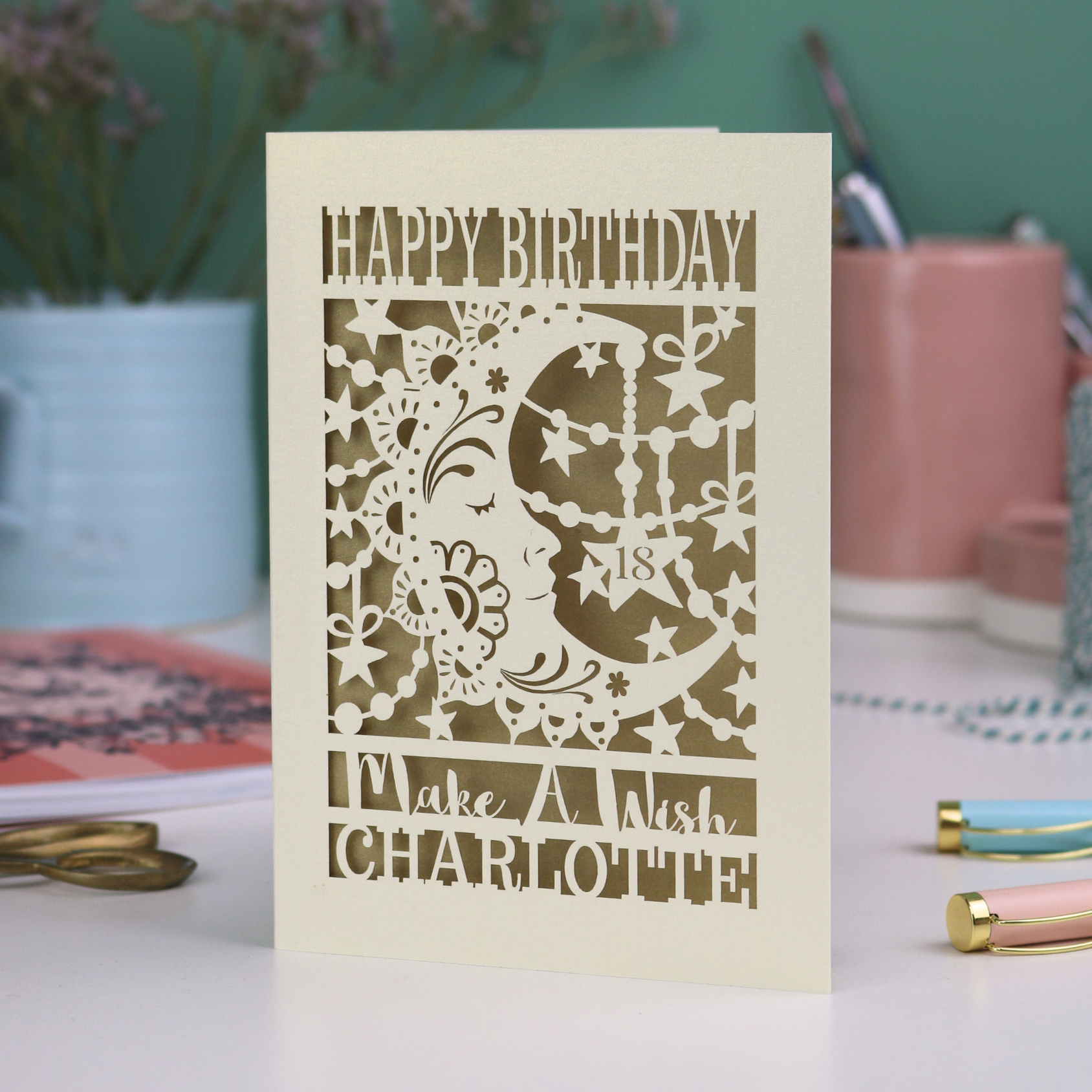 Laser cut moon 18th Birthday card with blue star and moon design on a desk with stationery items.