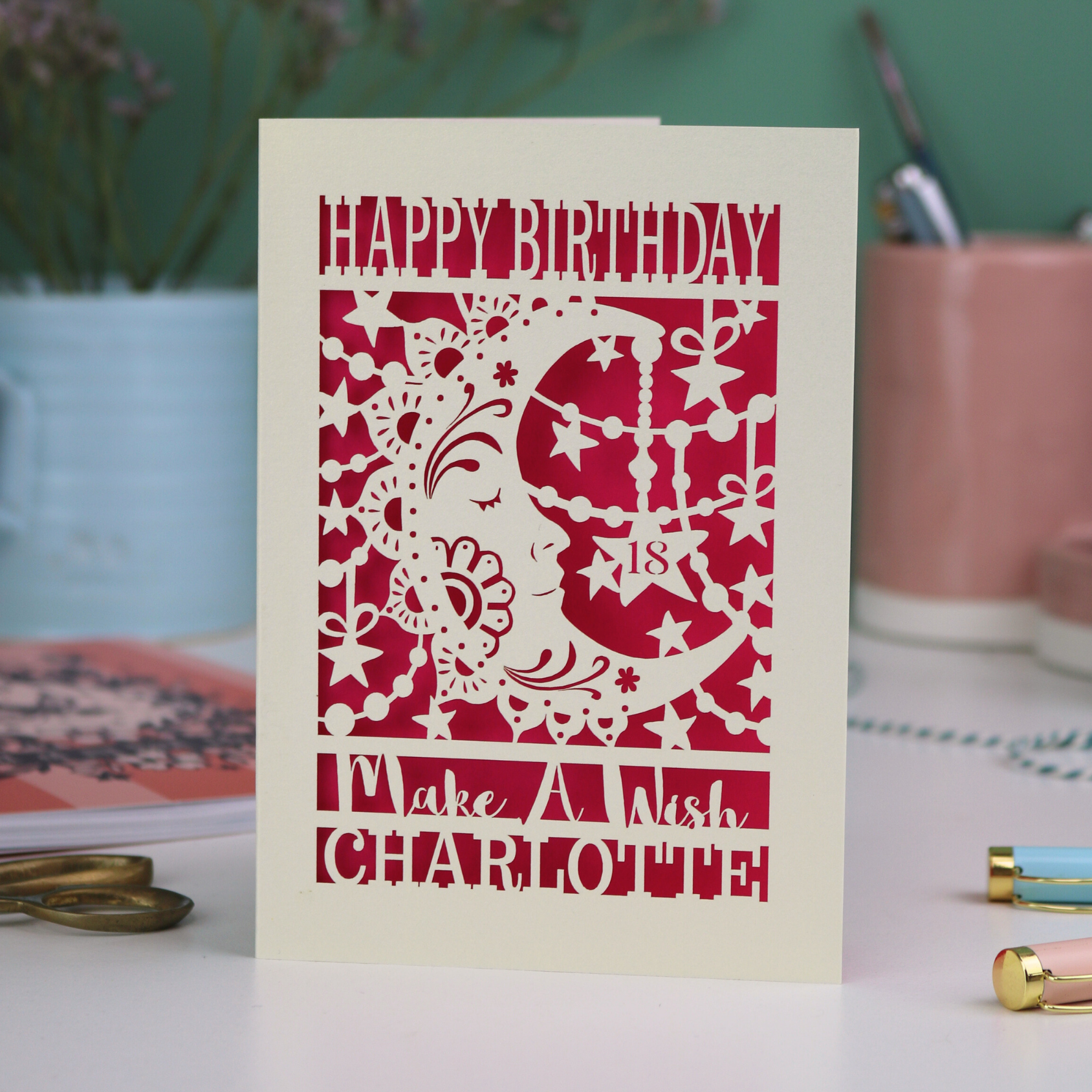 Laser cut moon 18th Birthday card with blue star and moon design on a desk with stationery items.