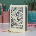 A personalised Birthday card with laser cut crescent moon design and text, 'Happy Birthday, Make a Wish Charlotte', on a desk with stationery items.