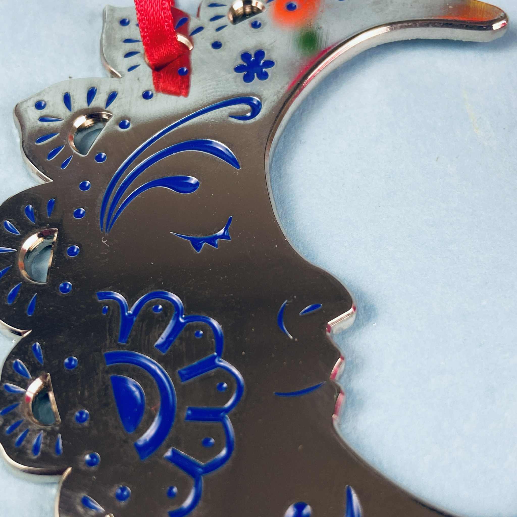 A silver and blue crescent moon Christmas tree ornament