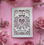 A cream cut out Mother's Day card that says "With love on Mothering Sunday". Card has a heart and flower details and a dusky pink paper insert
