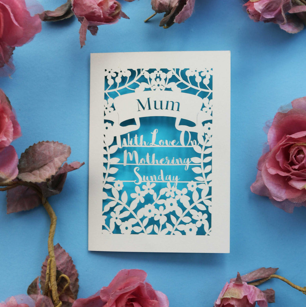 A mother's day card laser cut from cream card with a blue paper background
