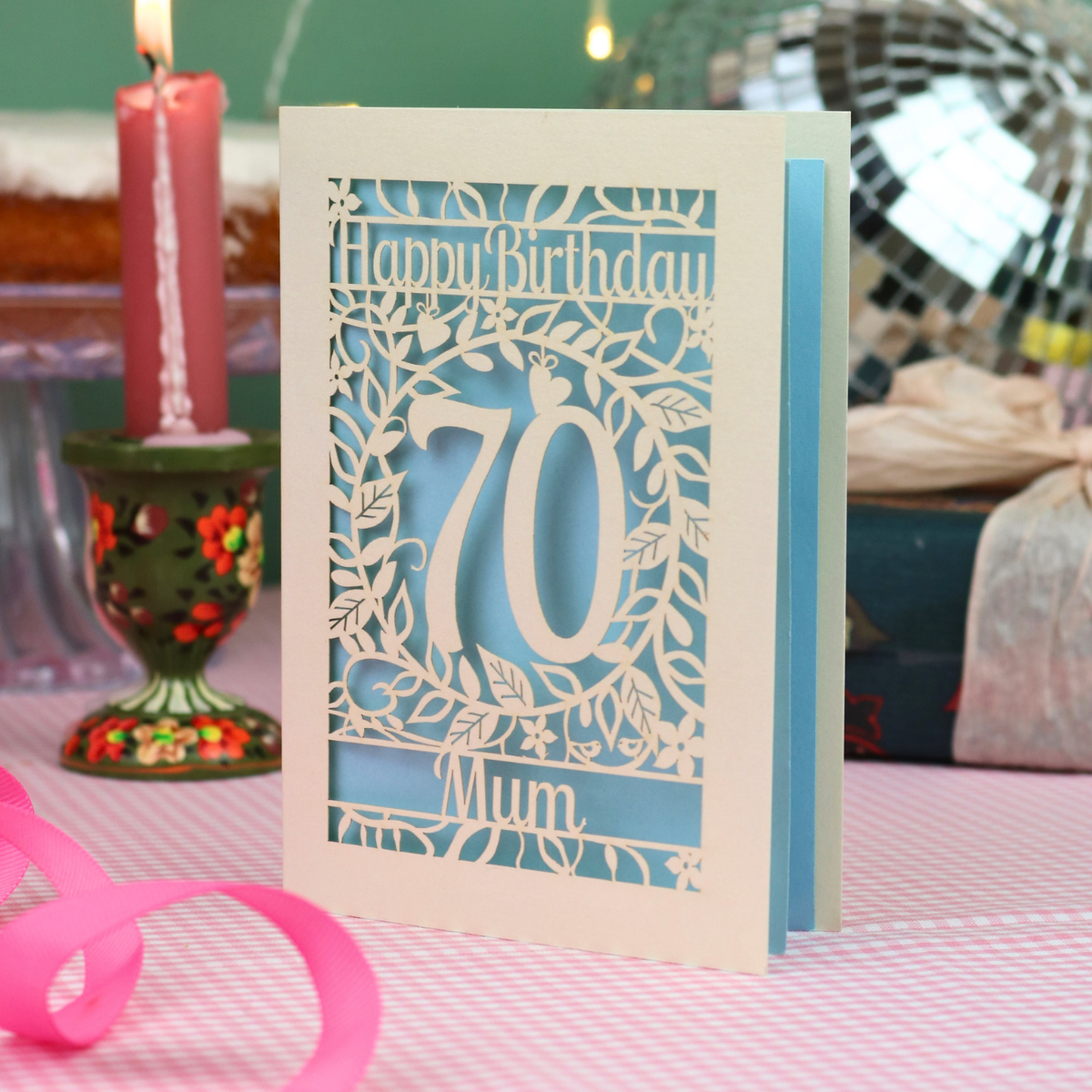 A personalised 70th birthday card, laser cut with floral design and 'Happy Birthday', with a name at the bottom and a big number 70 in the centre. 