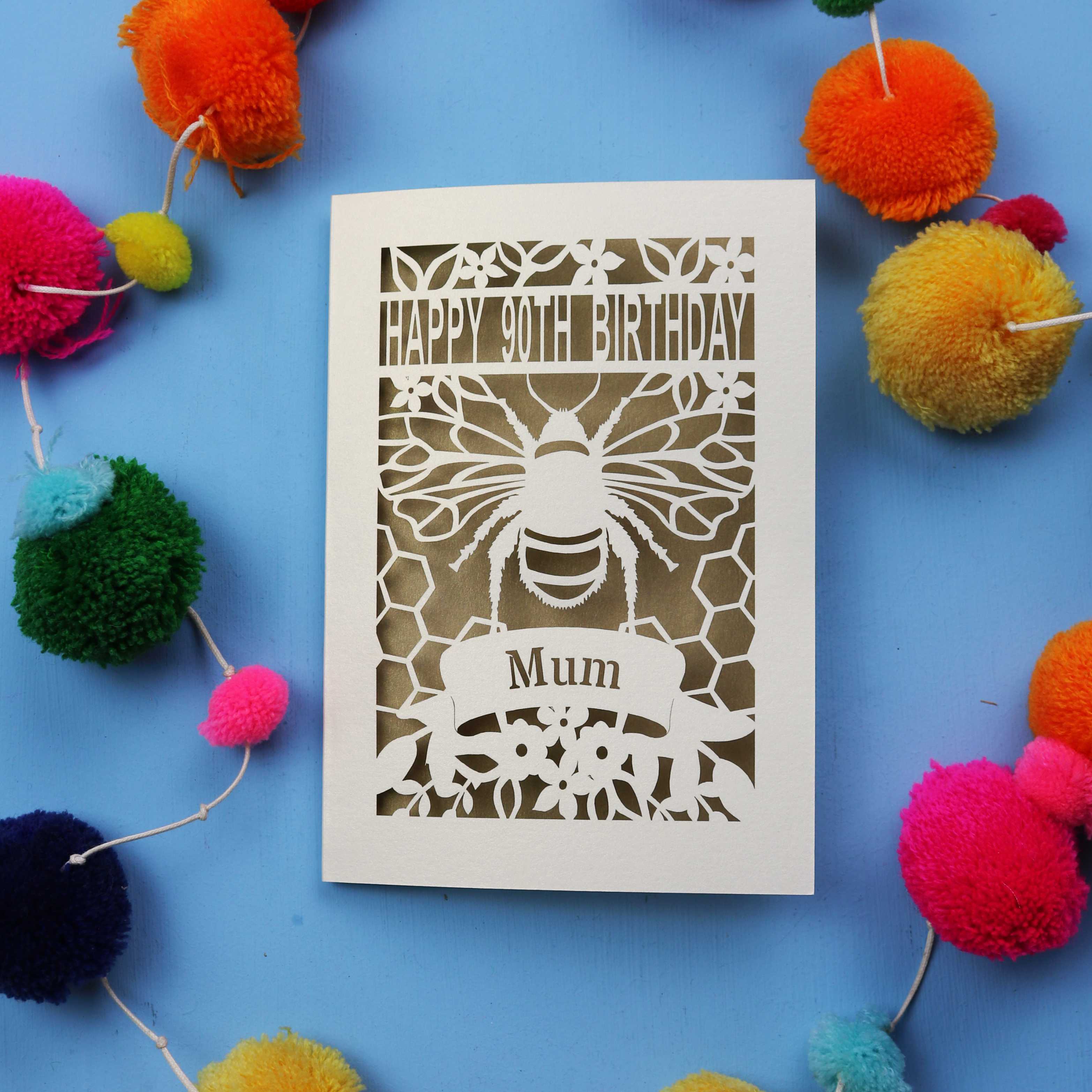 90th Birthday card with bee design and colourful pom-poms on a blue background