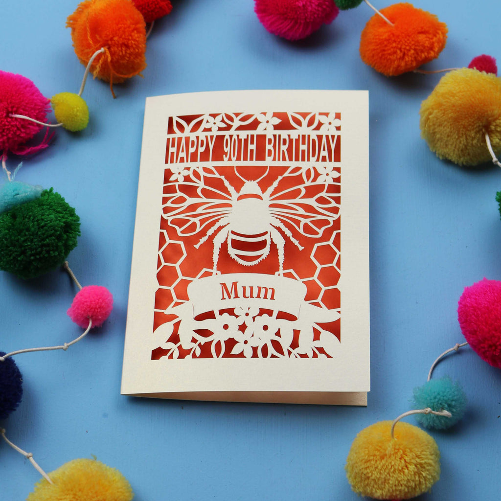 90th Birthday card with bee design and colourful pom-poms on a blue background