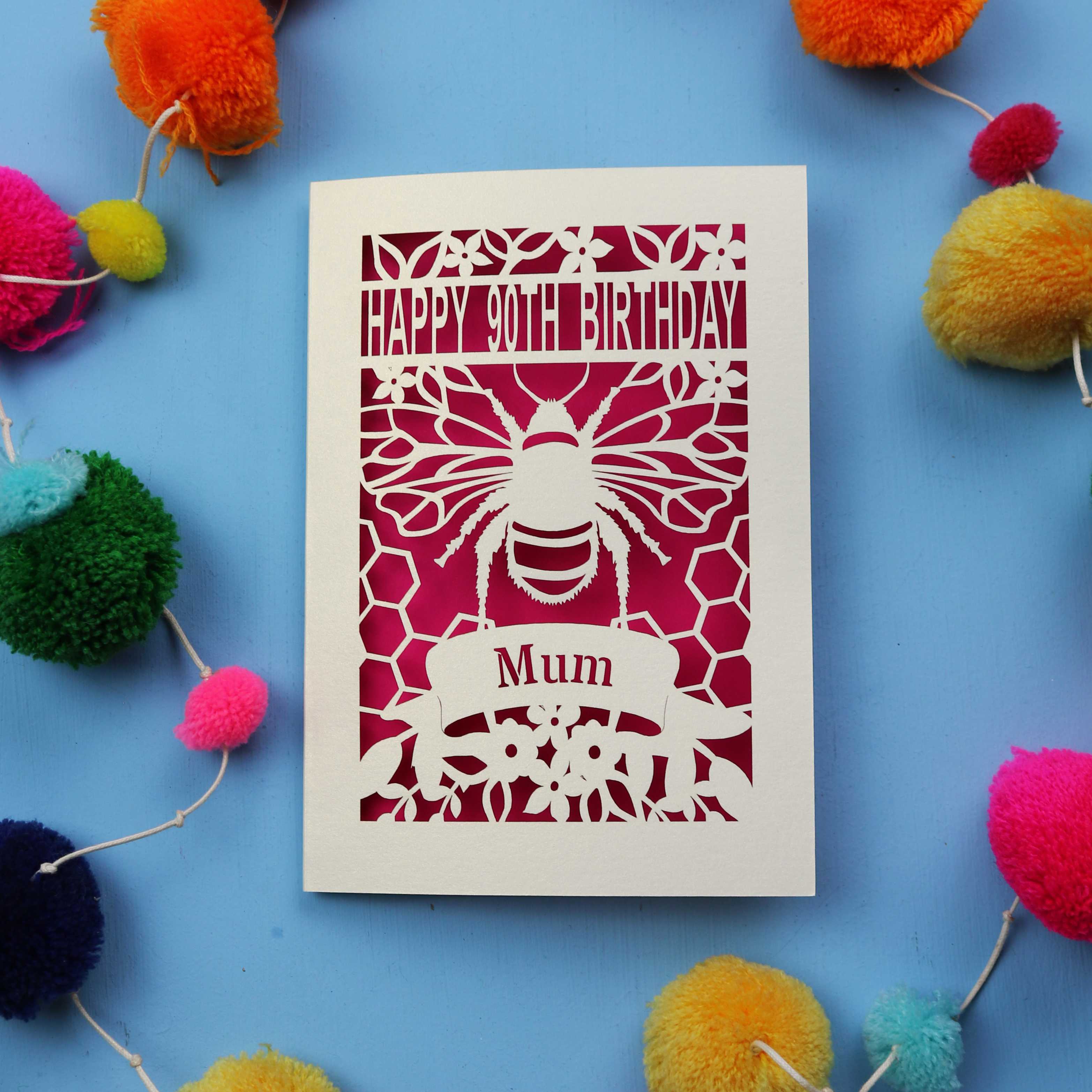 90th Birthday card with bee design and colourful pom-poms on a blue background