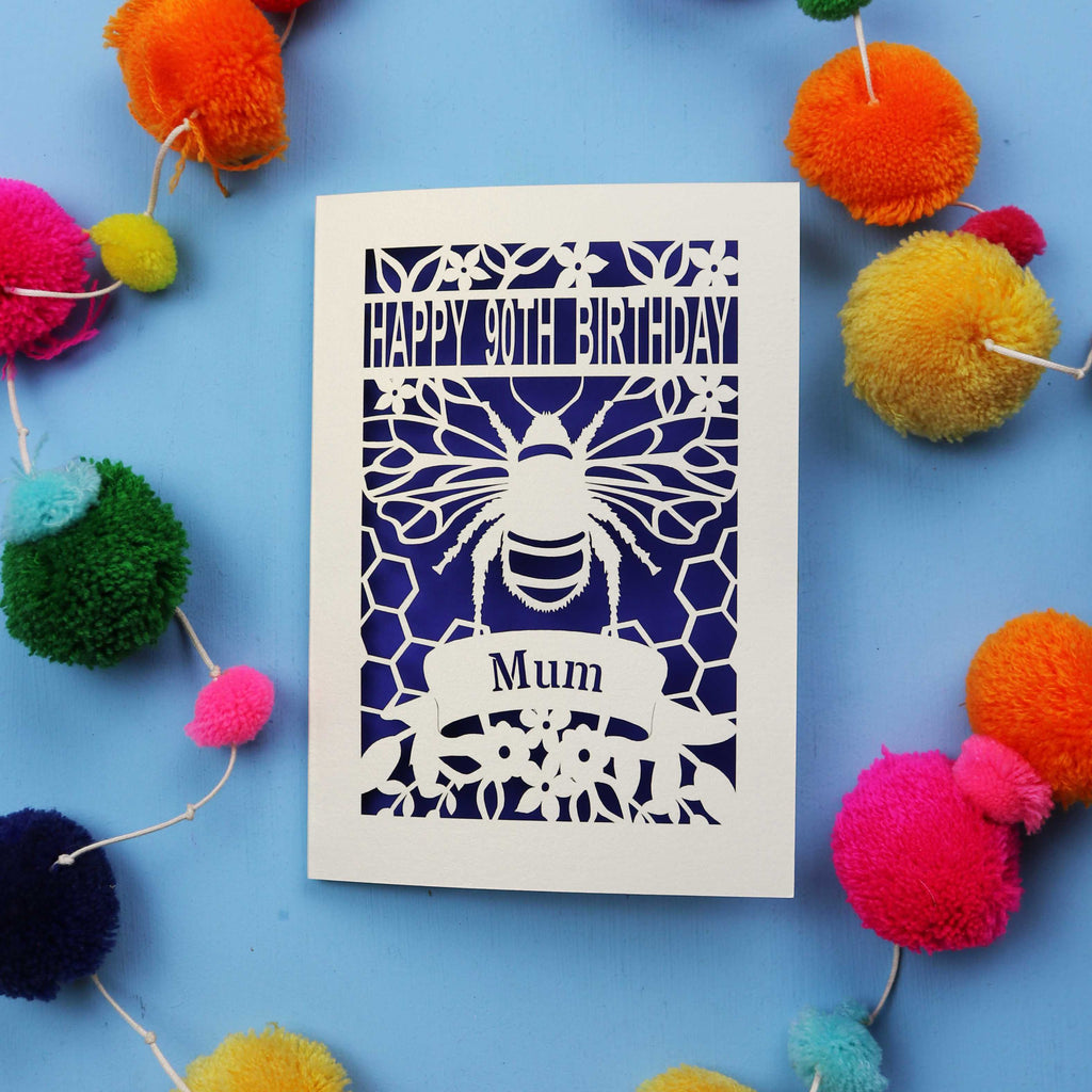 90th Birthday card with bee design and colourful pom-poms on a blue background