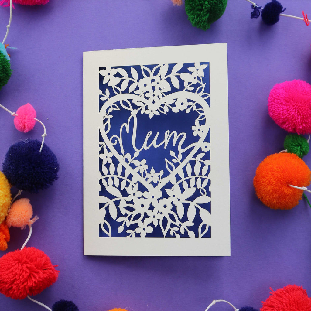 A paper cut mothers day card with "Mum" in a script font