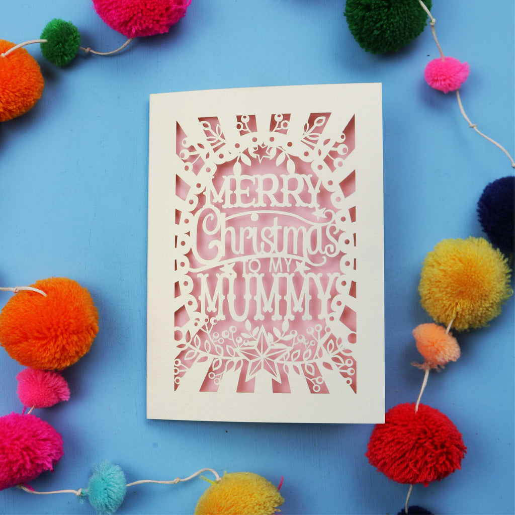 Paper cut Mummy Christmas card with 'Merry Christmas to my Mummy' text on a blue background with colourful pom-poms.