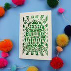 Laser cut Mummy Christmas card with 'Merry Christmas to my Mummy' text on a blue background with colourful pom-poms.