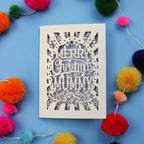 Laser cut Mummy Christmas card with 'Merry Christmas to my Mummy' text on a blue background with colourful pom-poms.