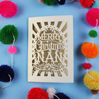 Laser Cut Christmas card with 'Merry Christmas Nan' text surrounded by colourful pom-poms on a blue background