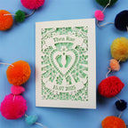 Personalised new baby card with personalised name and date, and intricate laser cut design on a blue background with colourful pom-poms.