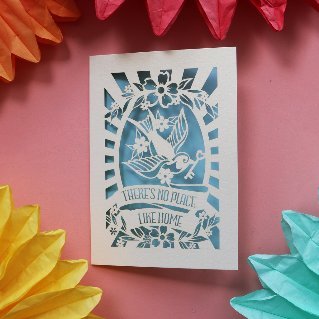 Laser cut new home cards featuring a bird holding a key and the words "There's no place like home."