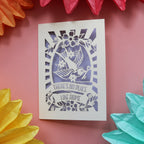 A cream and lilac unusual new home card with a bird holding a key and the words "There's no place like home."