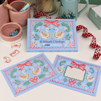 Set of decorative notecards with swan design on a table with stationery items.