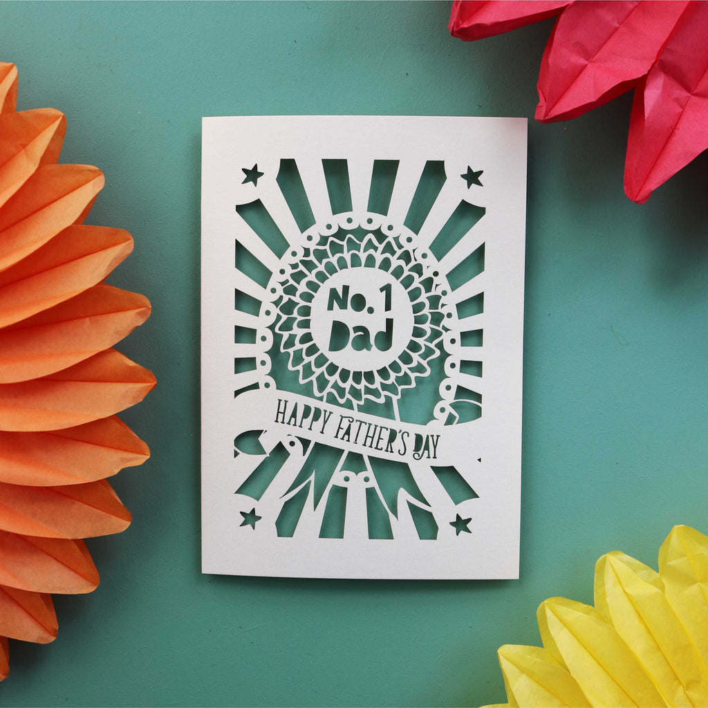 A fathers day card with a rosette and the words "no. 1 dad" and a banner underneath that says "happy Father's Day