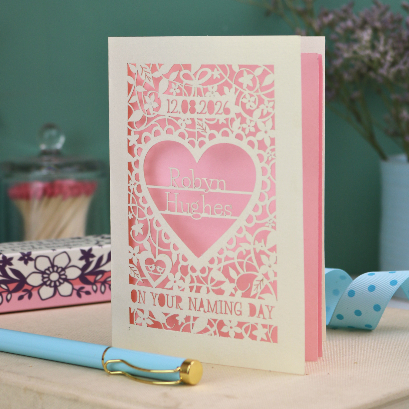Laser cut "on your naming day" card personalised with the date and the name of the recipient, with a floral heart border
