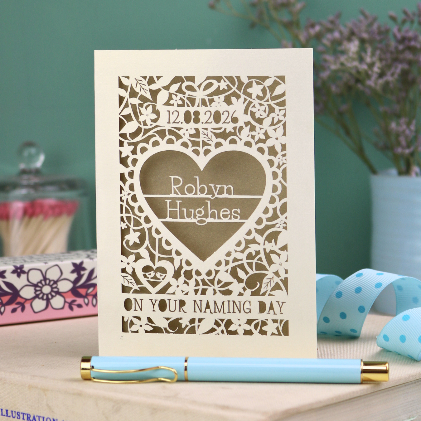 Laser cut "on your naming day" card personalised with the date and the name of the recipient, with a floral heart border