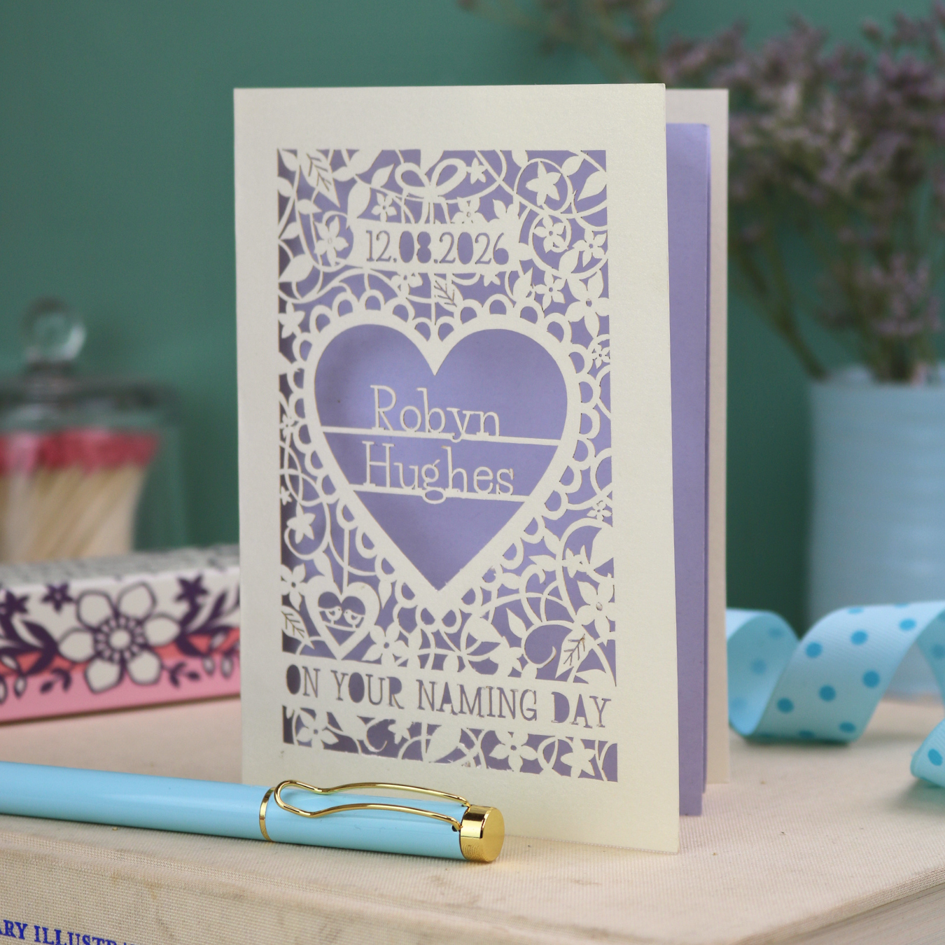 Laser cut out "on your naming day" card personalised with the date and the name of the recipient, with a floral heart border