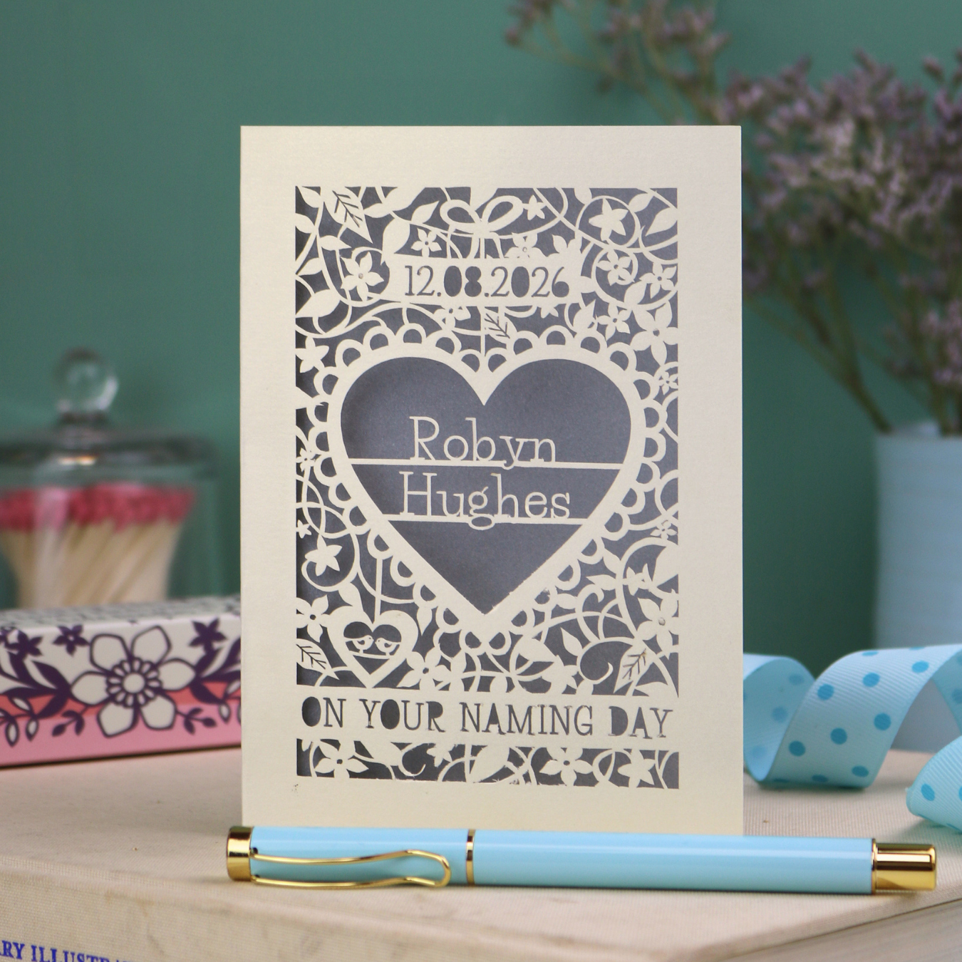 Laser cut "on your naming day" card personalised with the date and the name of the recipient, with a floral heart border