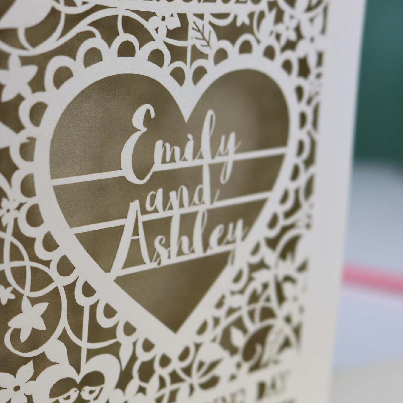 Decorative paper cut heart-shaped wedding card detail with 'Emily and Ashley' text