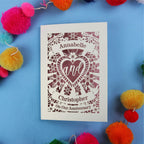 Personalised anniversary card with decorative heart design on a blue background with colourful pom-poms.