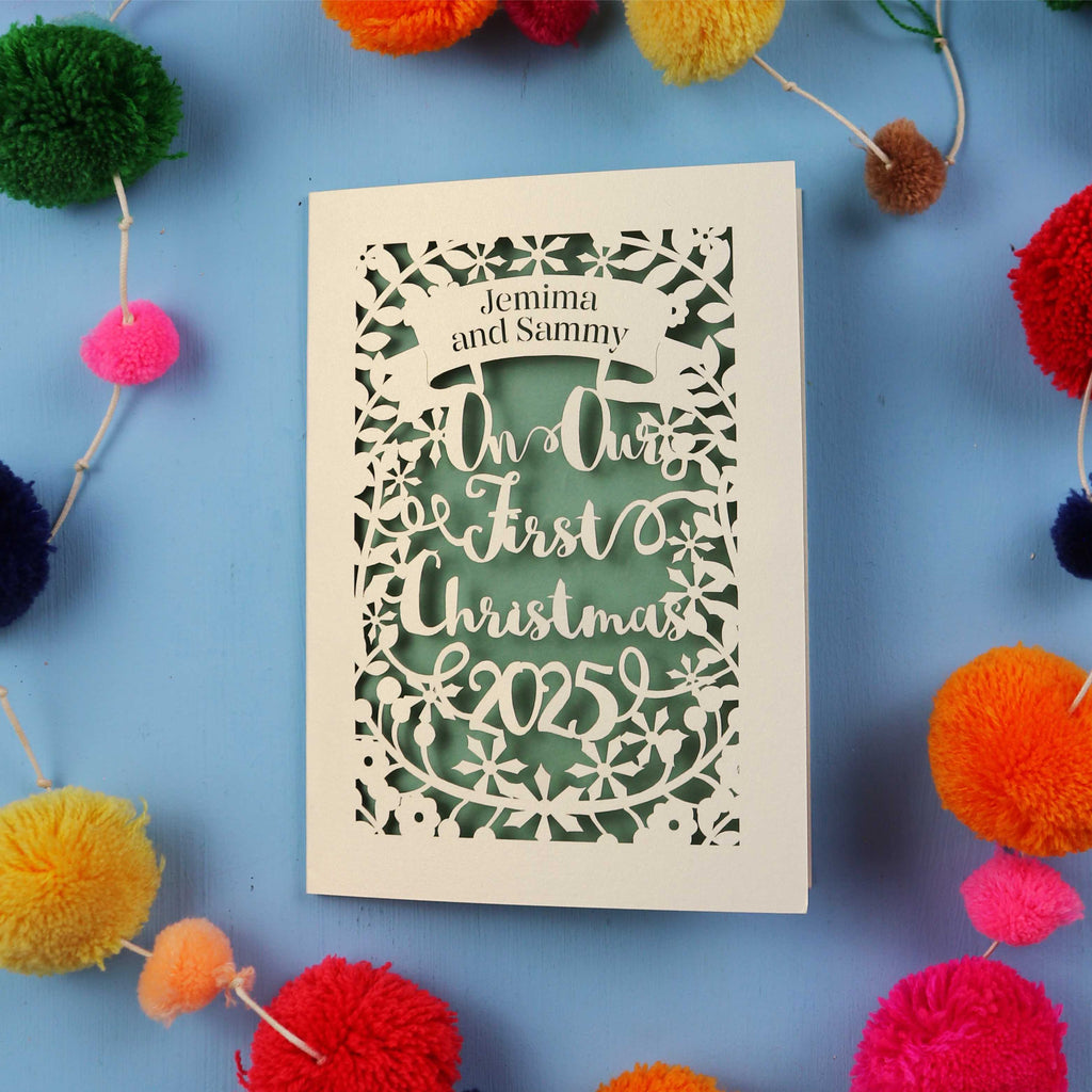 Personalized Our First Christmas card with decorative elements on a blue background