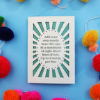 A cut out greeting card with a sun beam border and an oval shape in the centre. There is a solid oval shape in the centre with your own custom text cut out in a stencil font