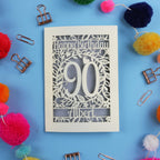 Birthday card with 'Happy Birthday 90 Albert' on a blue background with colourful pom-poms and paper clips.