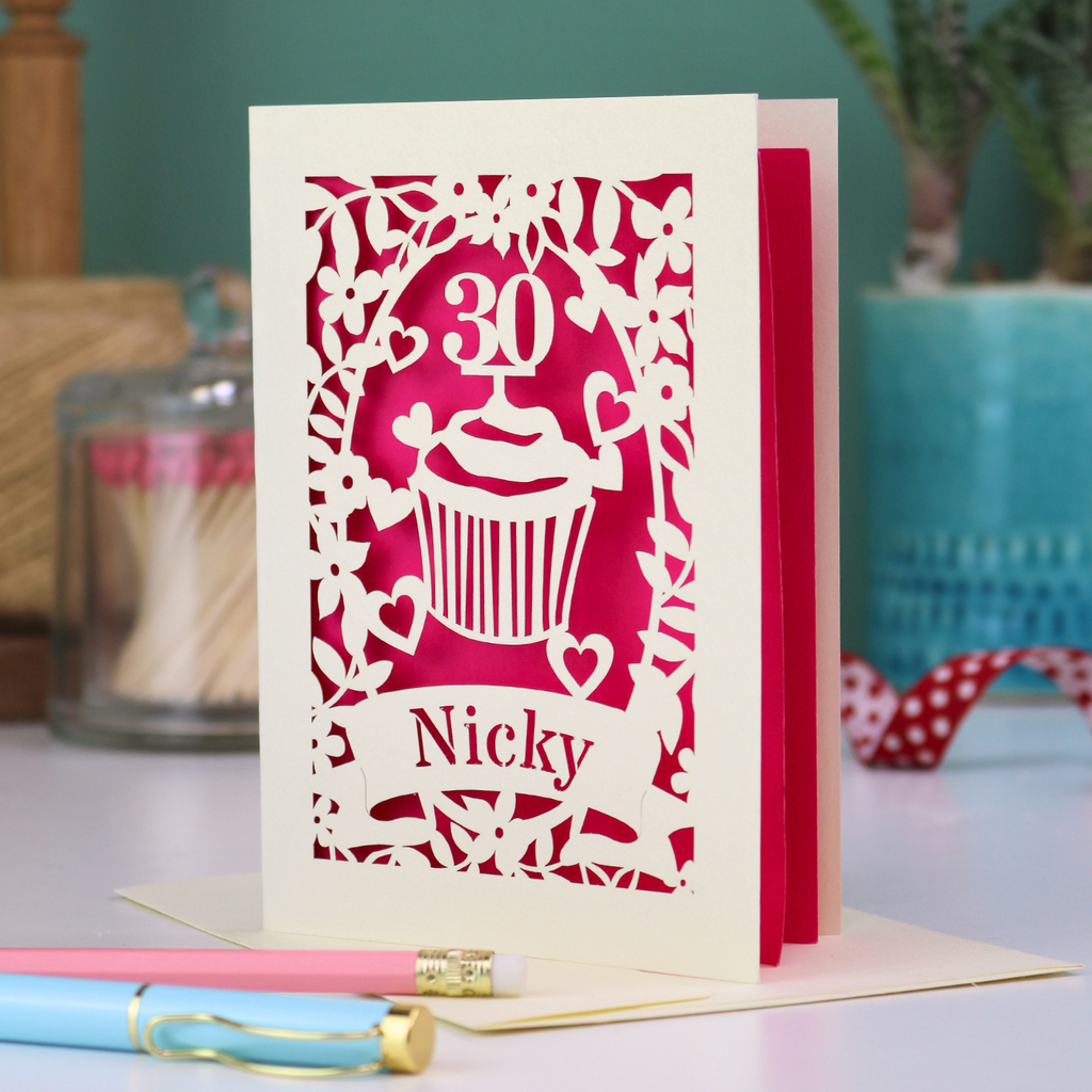 A laser cut 30th birthday card with cupcake design and personalised with a name in stencil font on a banner